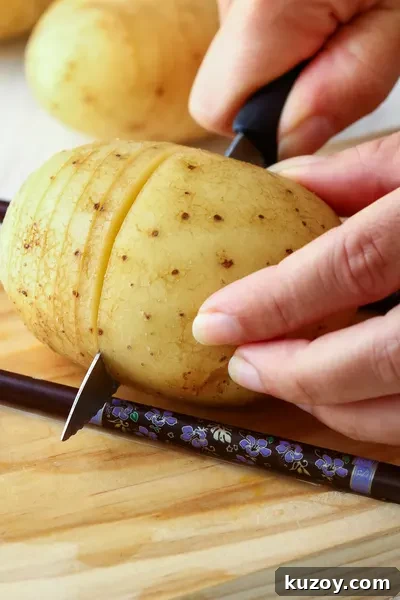 Hasselback Potatoes: Crispy Sliced Baked Potatoes with Garlic Butter 4 slicing between chopsticks
