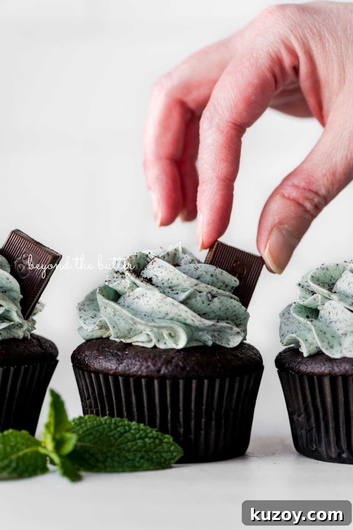 Placing an Andes mint on top of a mint chocolate cupcake for garnish.
