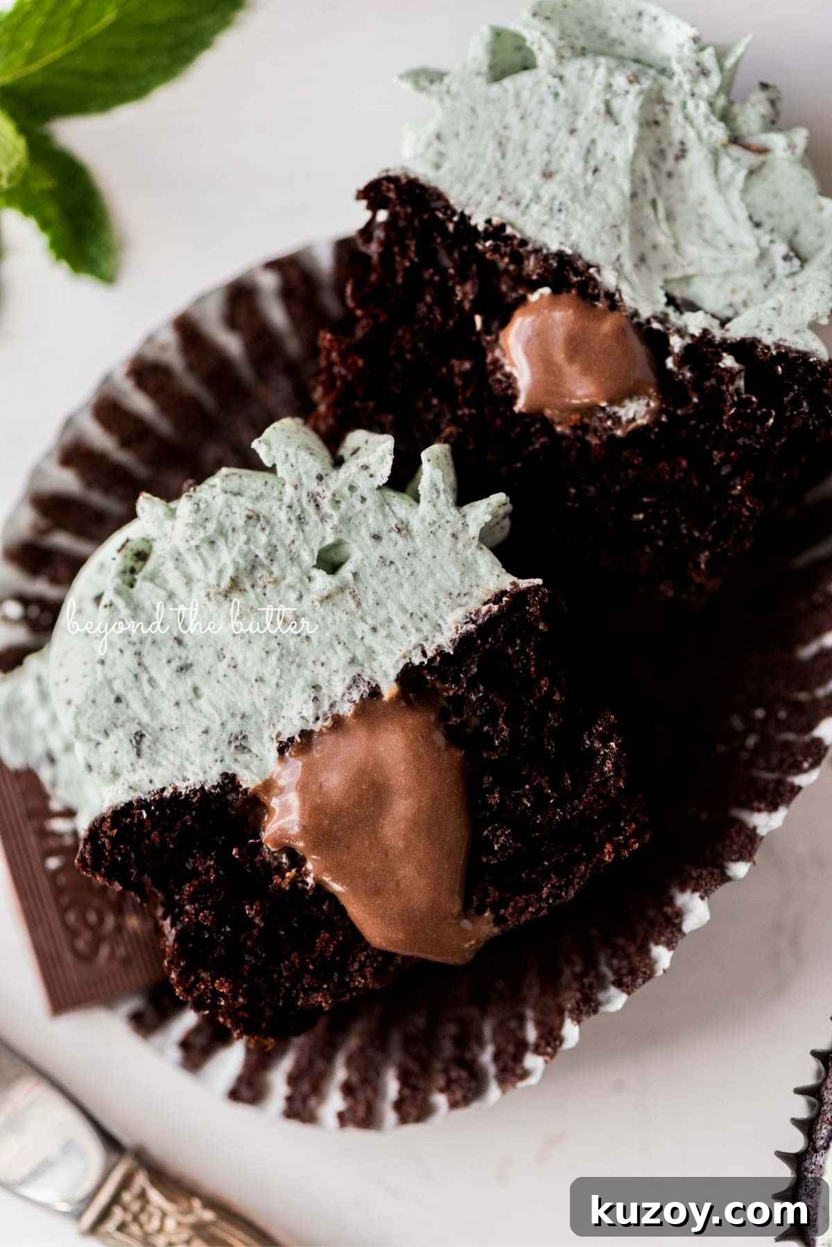 Sliced inside shot of mint chocolate cupcakes with mint chocolate ganache filling placed on an open cupcake liner.