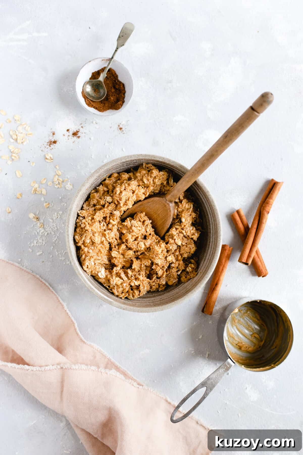 Coconut Peanut Butter Energy Bites with Warm Spices 4 Overhead shot of bowl with oats, coconut shreds and peanut butter mixture with wooden spoon