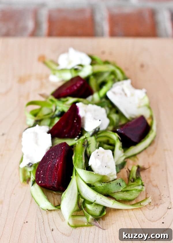Asparagus Ribbon Salad with Beets and Creamy Burrata 2 Closeup of asparagus ribbon salad on a wooden cutting board.
