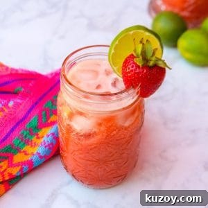 Refreshing Strawberry Limeade Recipe: Homemade Strawberry-Lime Cooler 10 Limonada de fresa in a glass, garnished with a strawberry and slice of lime