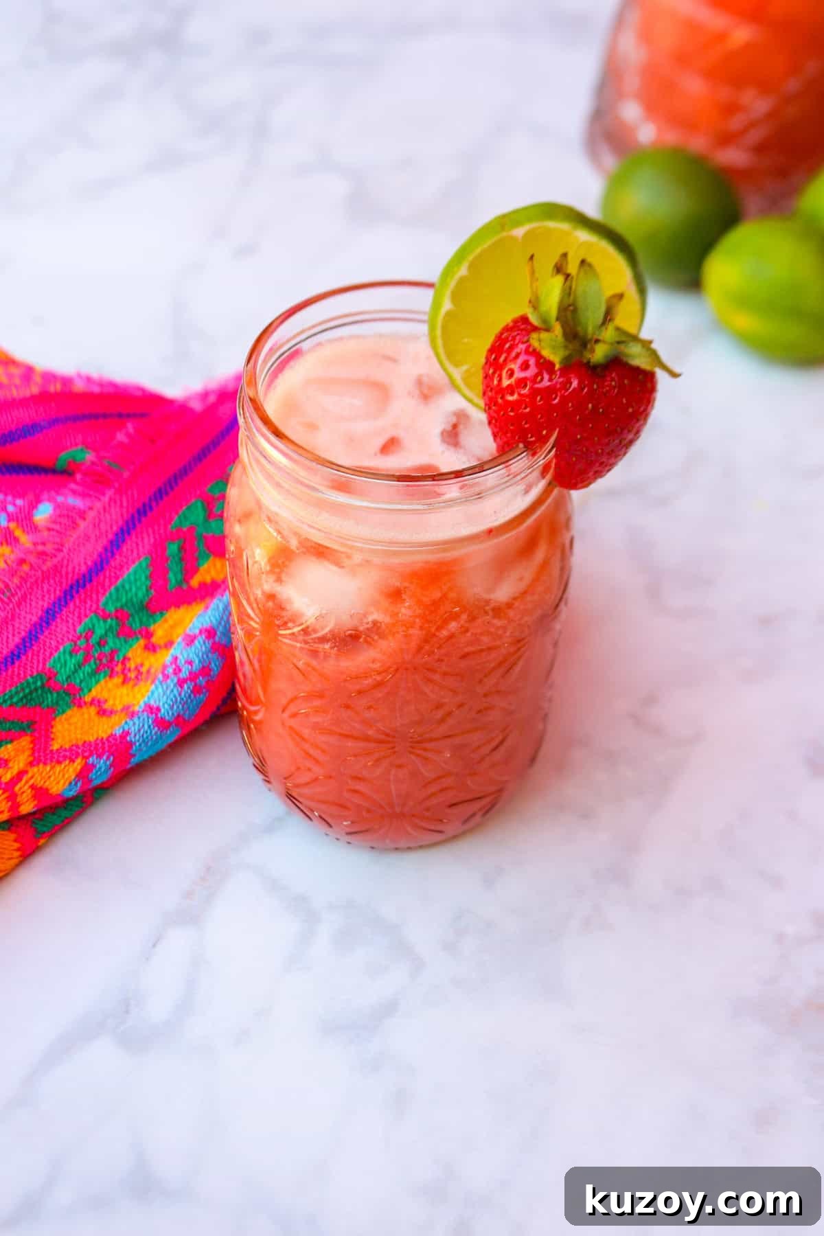 Refreshing Strawberry Limeade Recipe: Homemade Strawberry-Lime Cooler 2 Limonada de fresa in a glass, garnished with a strawberry and slice of lime