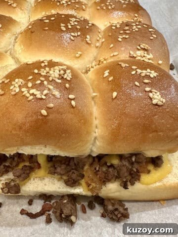 A pan of baked cheeseburger sliders on a baking sheet.