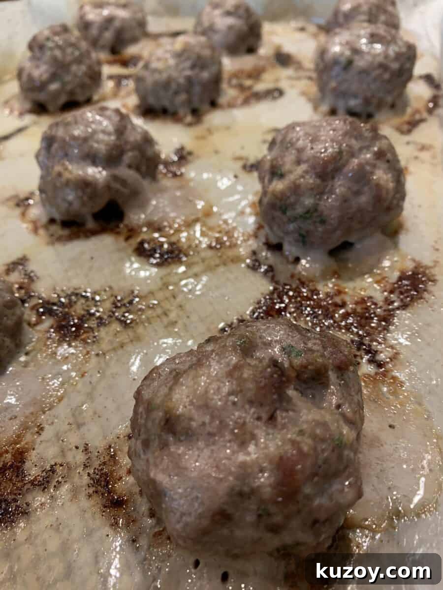 Cooked meatballs on a baking sheet.