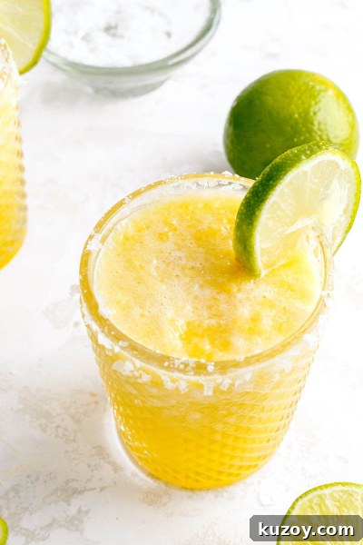 Frozen Pineapple Margarita Recipe — 4-Ingredient Tropical Cocktail 7 frozen pineapple margarita with lime on glass