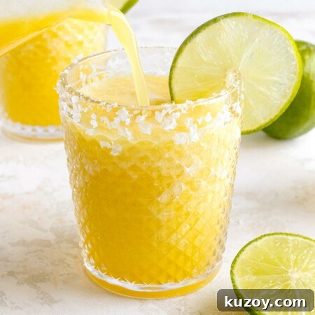 Frozen Pineapple Margarita Recipe — 4-Ingredient Tropical Cocktail 8 pineapple margarita being poured in glass