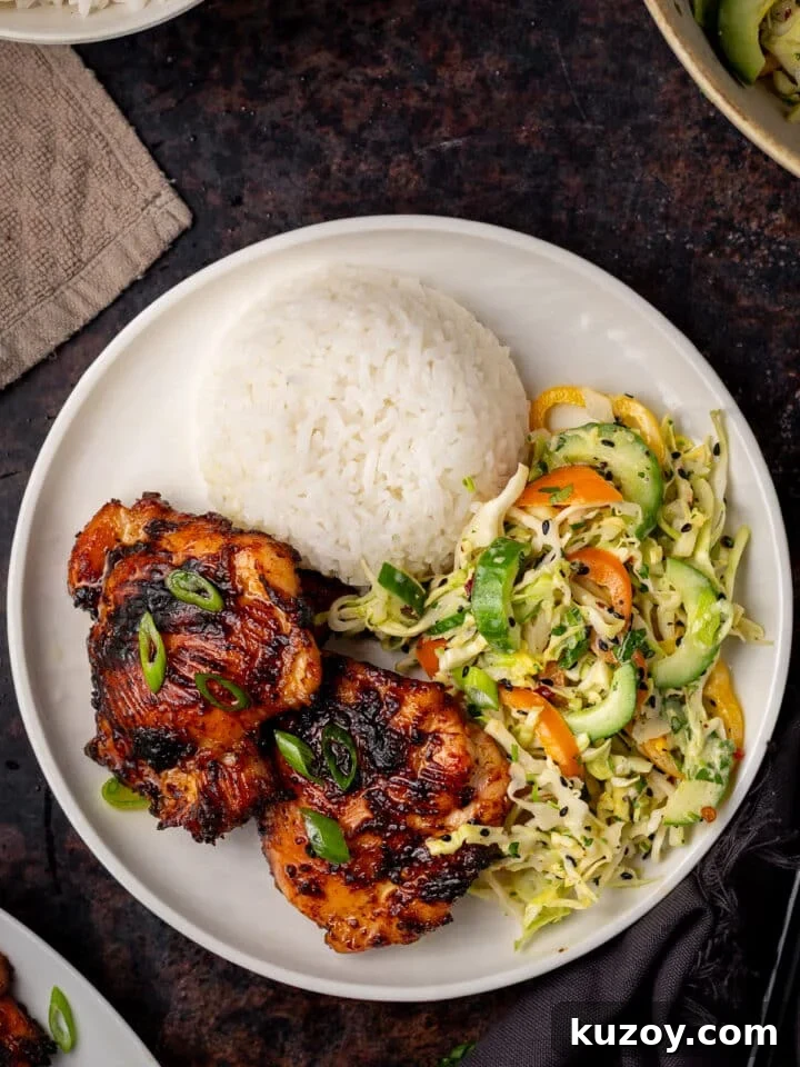 Asian Cucumber Slaw with Tangy Sweet Chili Dressing — Fresh Crunch and Zing 9 white plate with mound of white rice, two chicken thighs and serving of Asian cucumber slaw