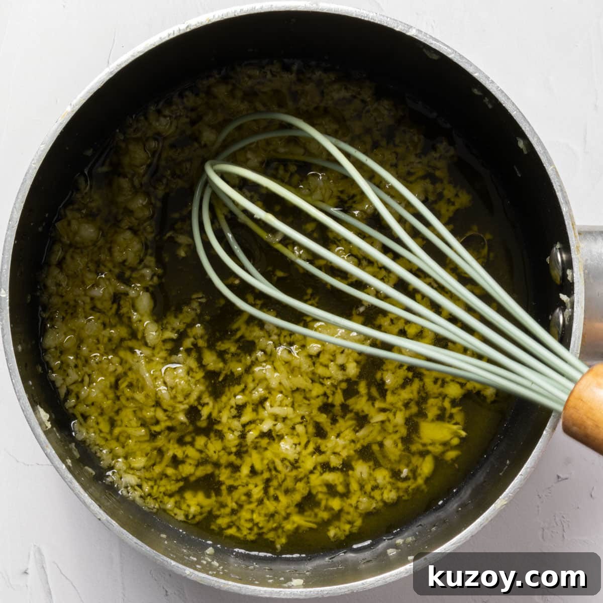 Toasted Garlic Salad with Crispy Garlic Dressing 4 A whisk in a pan of minced garlic in golden olive oil.