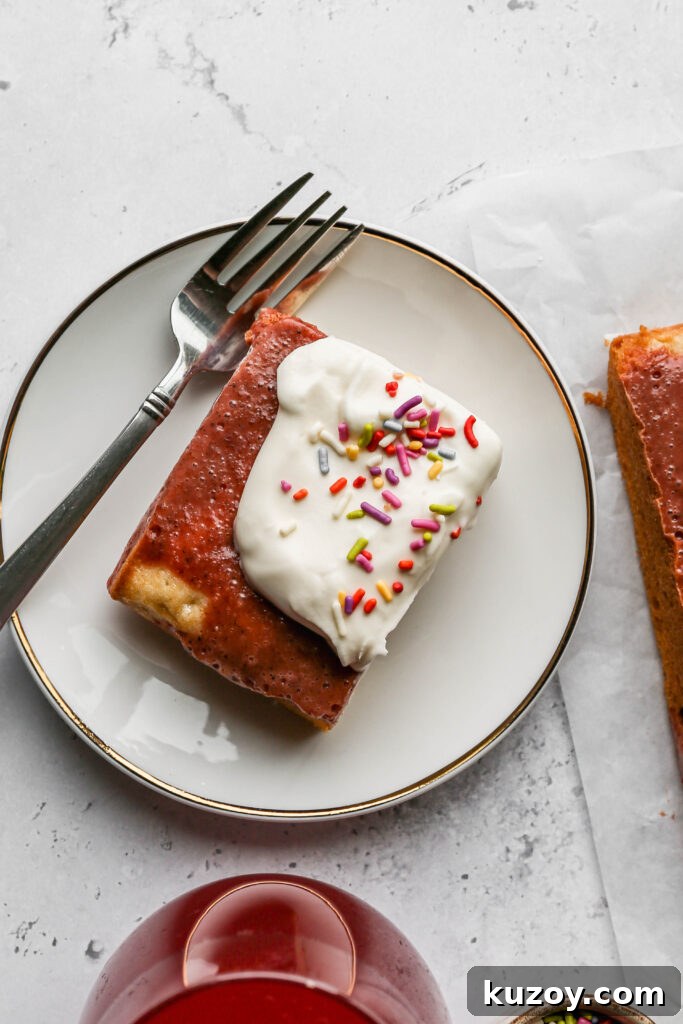 Gluten-Free Vanilla Pudding Poke Cake Recipe for Moist Dessert 3 a slice of gluten free easter poke cake on a white plate next to a small bowl of bright colored sprinkles and a stemless wine glass of a red drink.