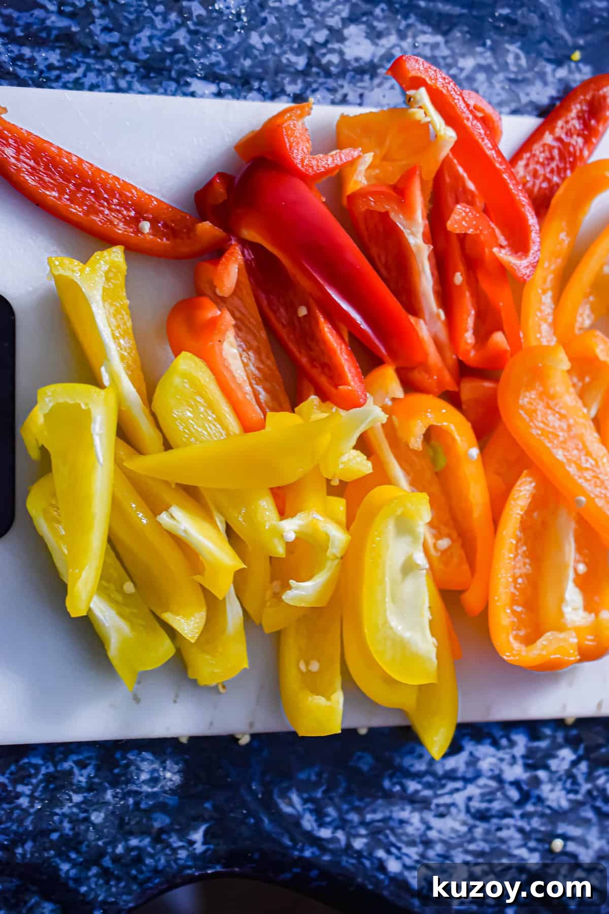 One-Pan Sausage and Peppers Recipe for Quick Weeknight Meals 5 The peppers are sliced on a cutting board.