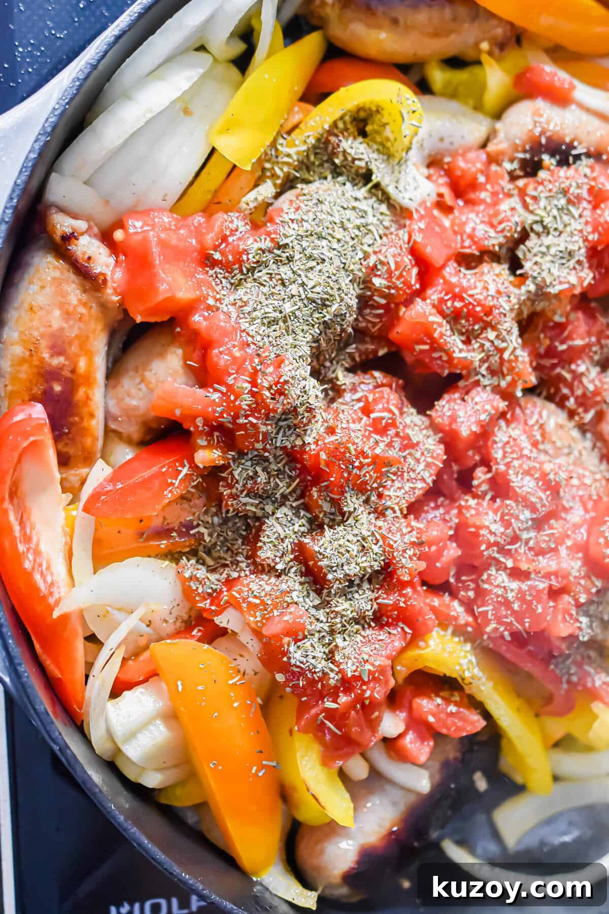 One-Pan Sausage and Peppers Recipe for Quick Weeknight Meals 9 The tomatoes and Italian seasoning are added to the pot.