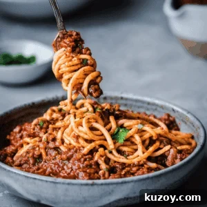 red lentil bolognese twirling on a fork