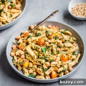Bowl of creamy vegan zucchini pesto pasta with fork in it