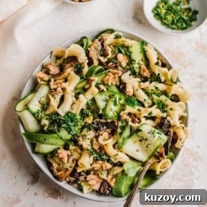 bowl of roasted eggplant pasta with fork and ingredient bowls to the side of it