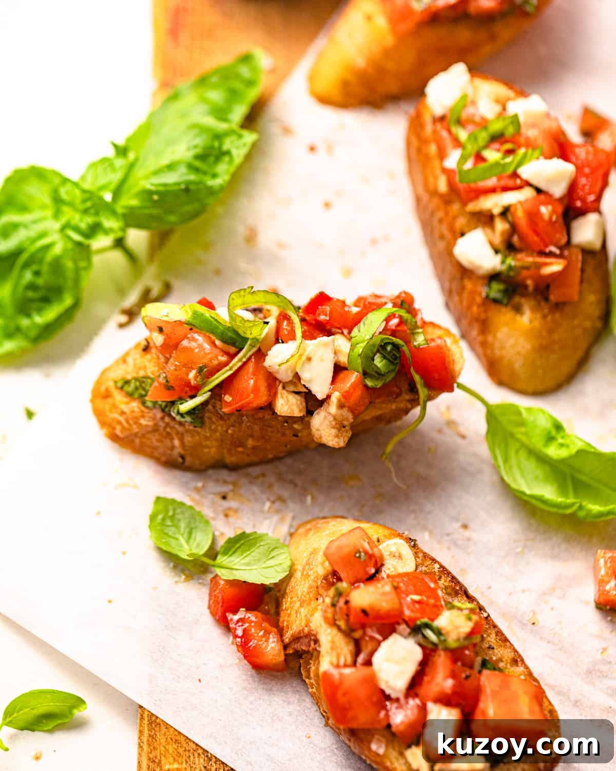 finished mozzarella bruschetta on a piece of parchment paper.