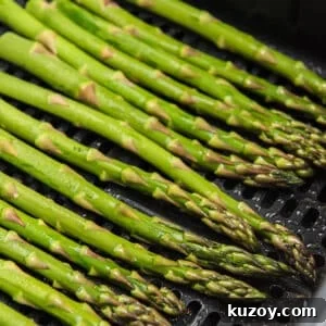 Crispy Air Fryer Asparagus Recipe with Garlic and Lemon 9 asparagus in the air fryer.
