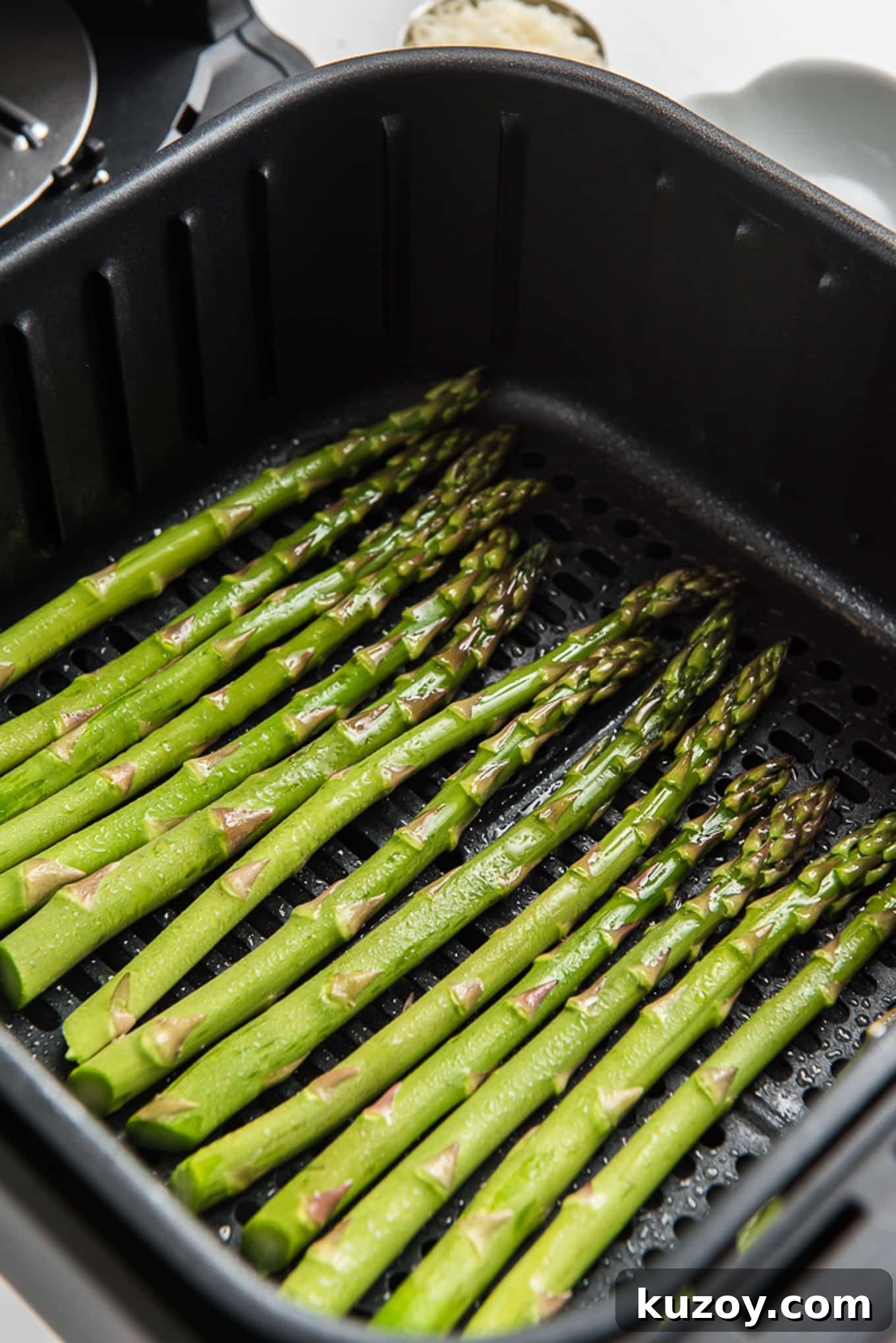 Crispy Air Fryer Asparagus Recipe with Garlic and Lemon 5 Asparagus at the bottom of an air fryer basket.