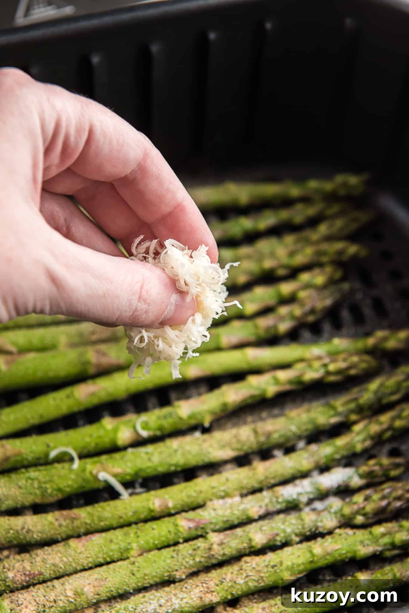 Crispy Air Fryer Asparagus Recipe with Garlic and Lemon 6 Sprinkling asparagus with parmesan cheese.