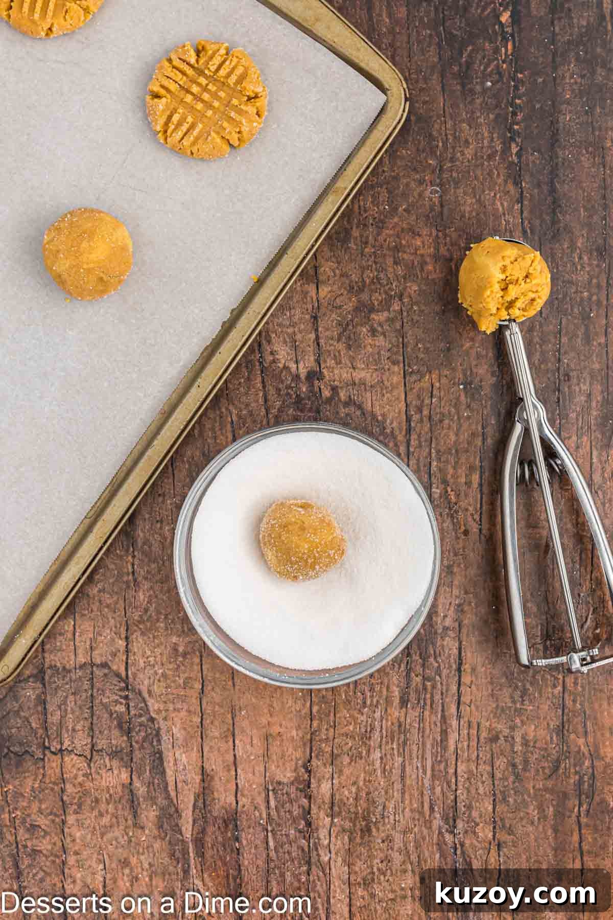 Dough balls dipped in a bowl of sugar.