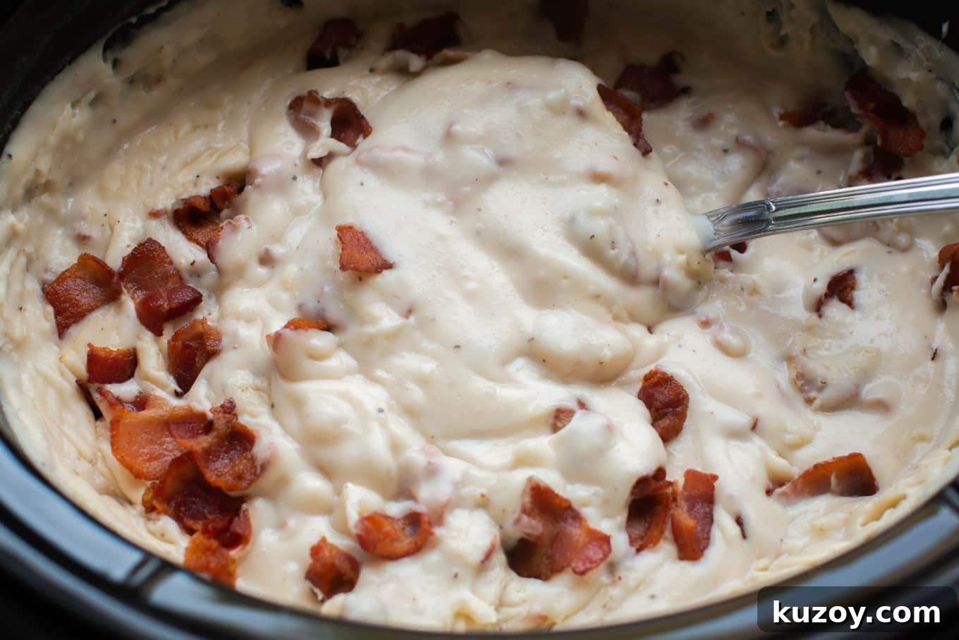 Creamy Slow Cooker Potato and Bacon Soup Recipe 4 close up of potato soup with metal ladle.
