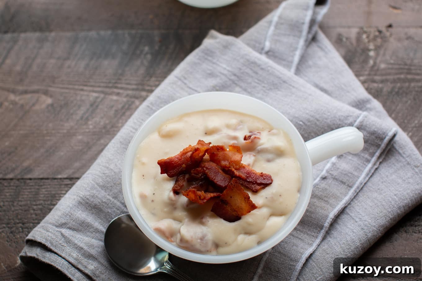 Creamy Slow Cooker Potato and Bacon Soup Recipe 5 white milk glass bowl with potato soup in it.