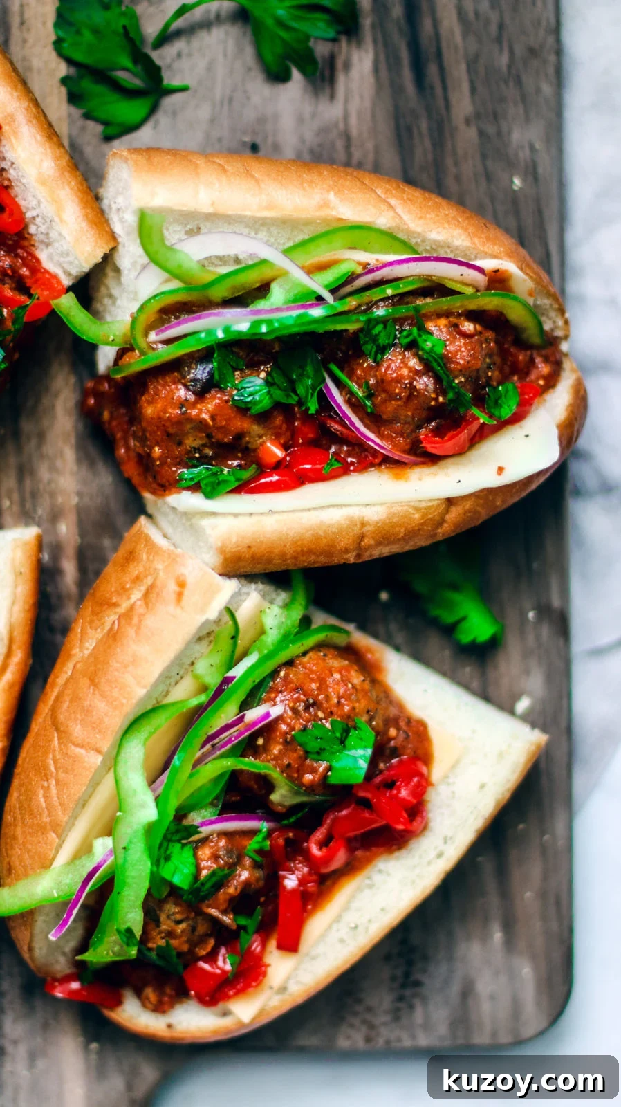 Close up of loaded meatball sub sandwiches on a serving platter.