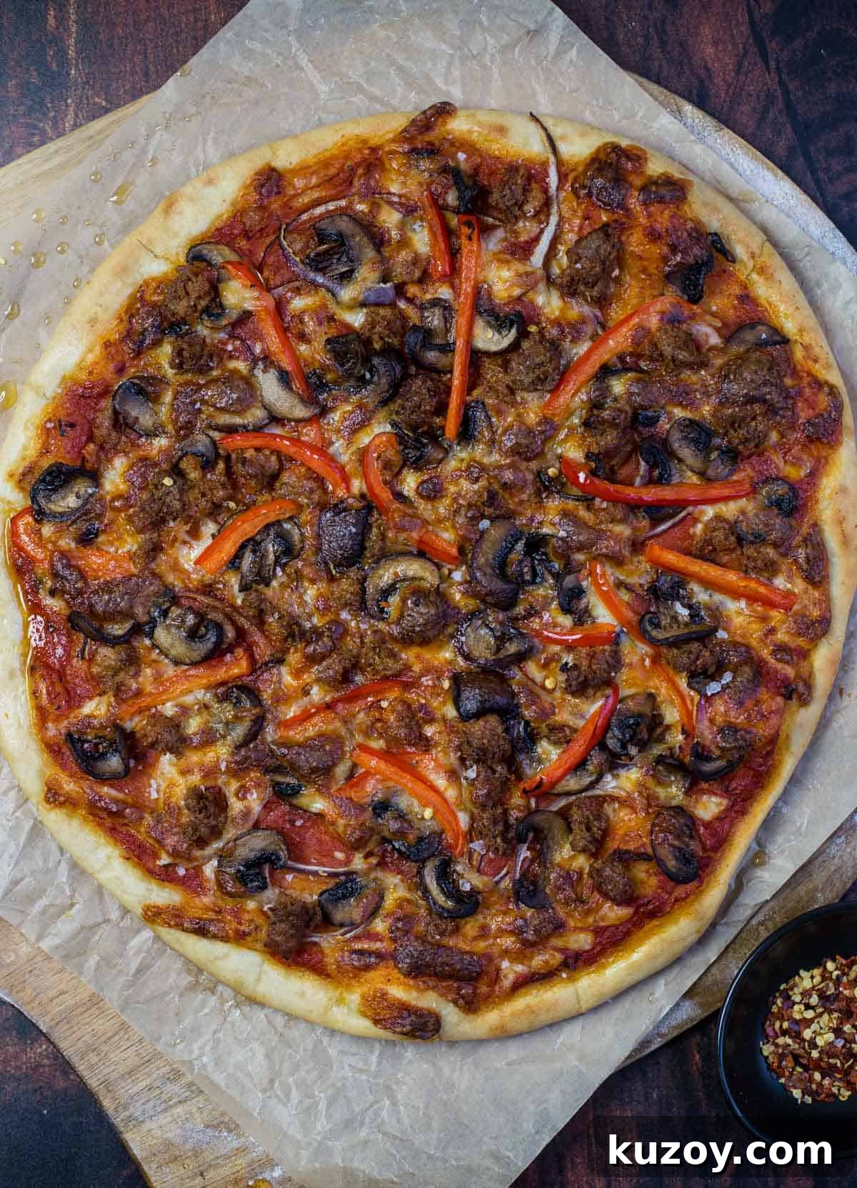 A Pellet Grilled Pizza Topped with Mushrooms, Sausage, and Peppers