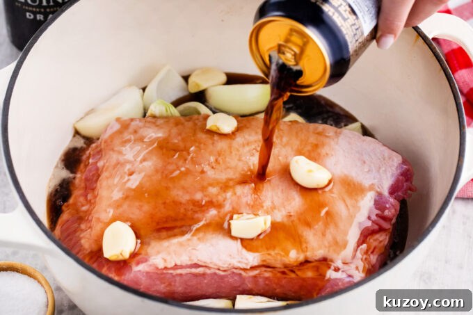 Dutch Oven Corned Beef Braised in Guinness 5 Adding Guinness beer to a pot with corned beef brisket.