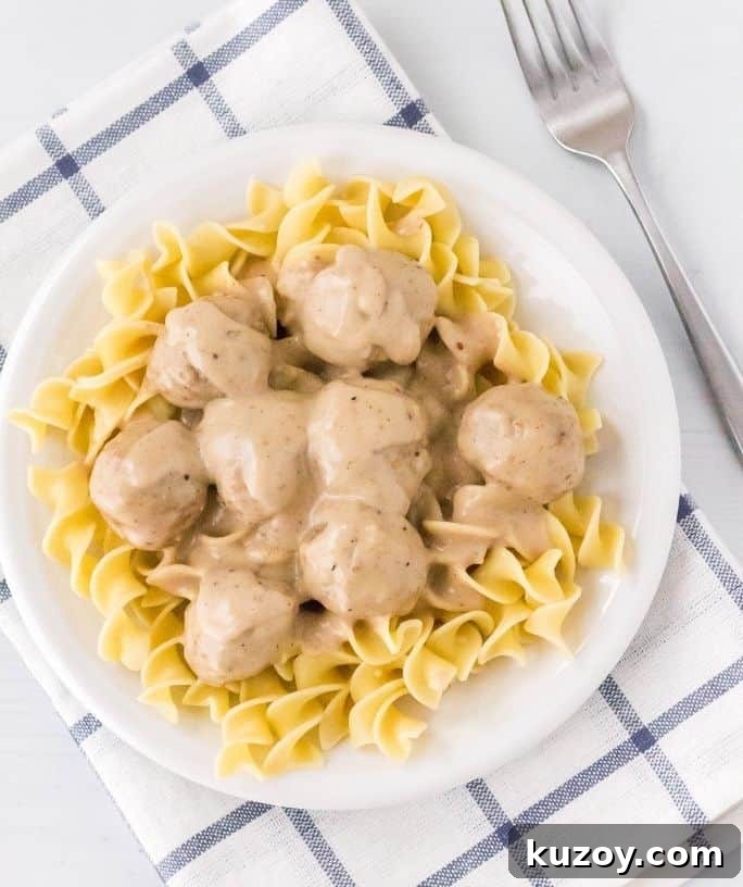 overhead view of a white plate with egg noodles topped with Instant Pot swedish meatballs