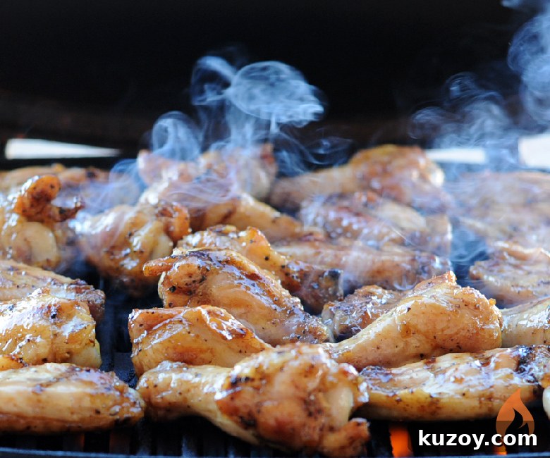 Tennessee Honey-Glazed Grilled Chicken Wings 5 chicken wings cooking on a grill with smoke