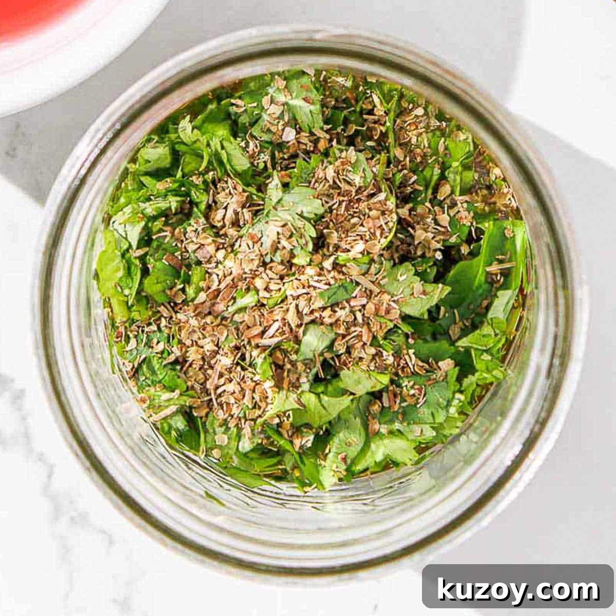 Ingredients for cilantro chimichuri in a glass jar.