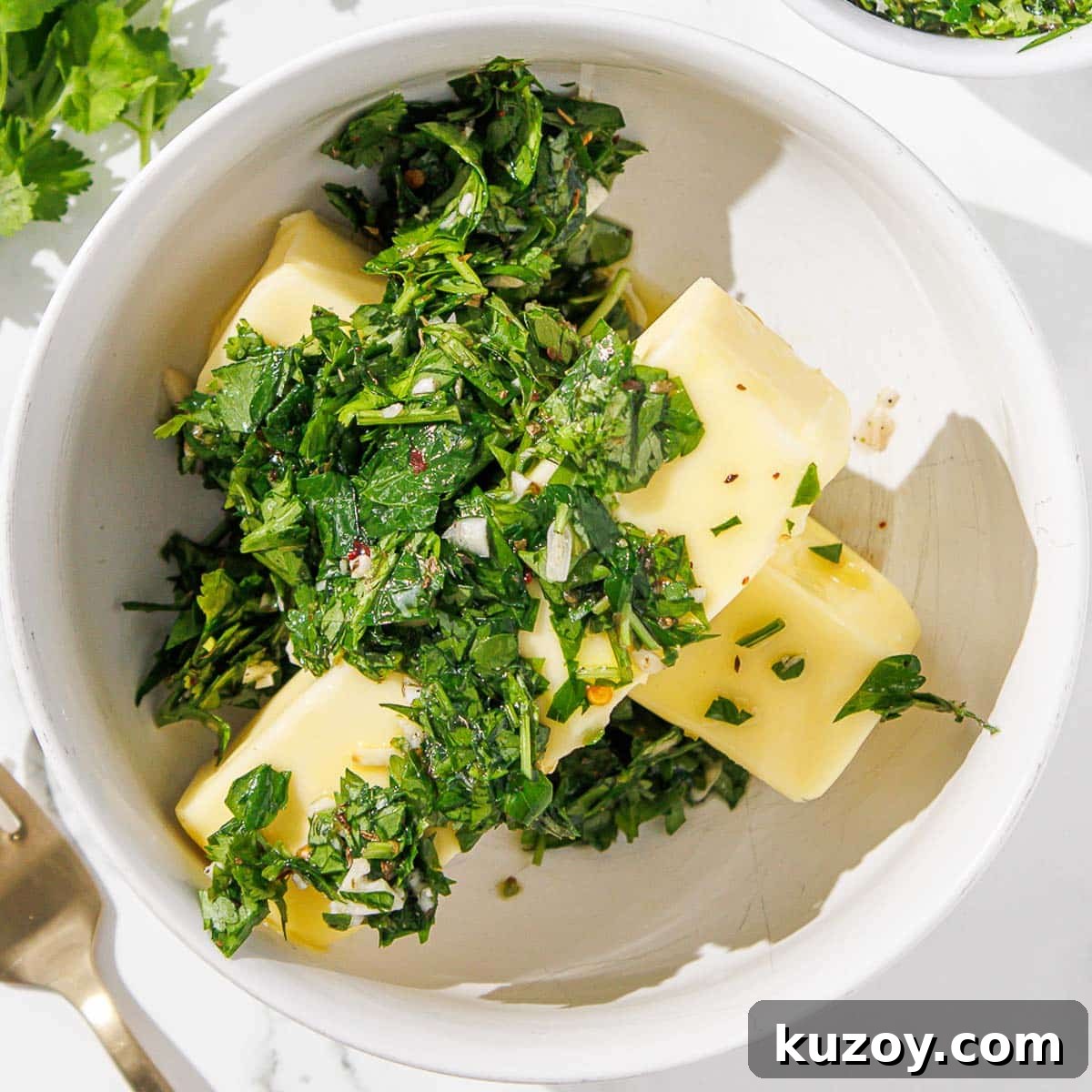 Chimichurri is added to a dish with softened butter.