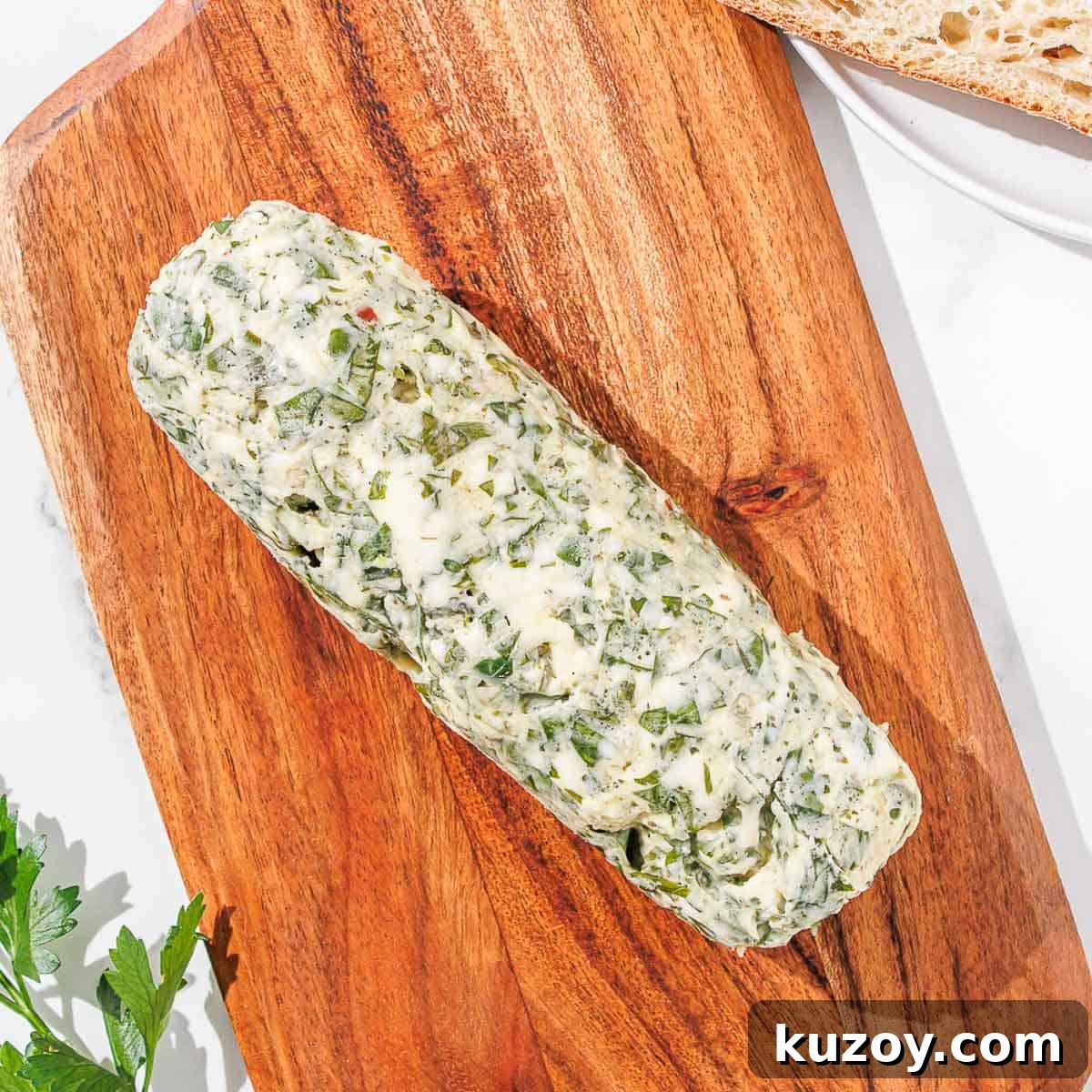 Finished chimichurri butter on a wooden cutting board.