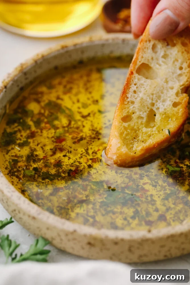 Bread dipped into olive oil dip A slice of bread being dipped into olive oil dip.