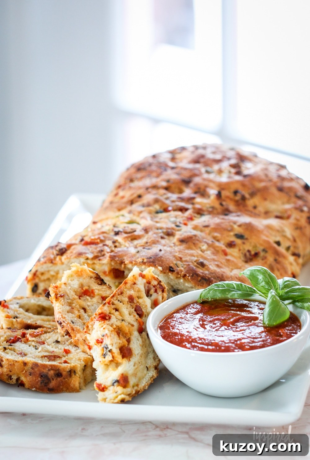 How to Make Homemade Pizza Bread (Crispy, Cheesy Recipe) 6 loaf of homemade pizza bread on a platter served with pizza sauce.