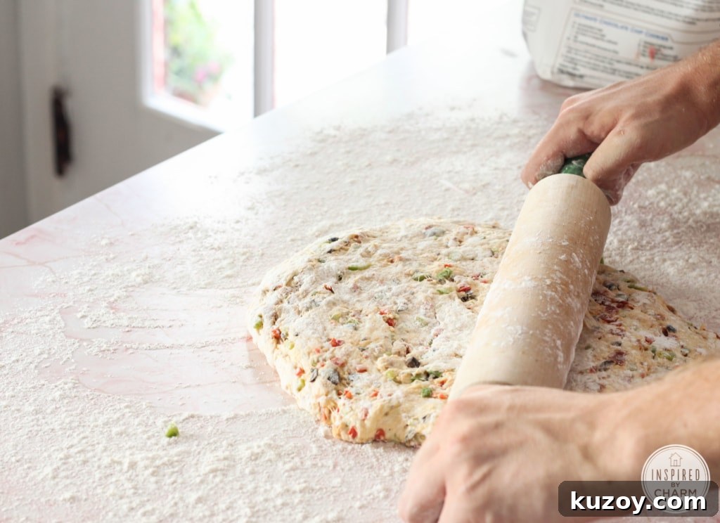 How to Make Homemade Pizza Bread (Crispy, Cheesy Recipe) 8 person rolling out pizza dough with a wooden rolling pin