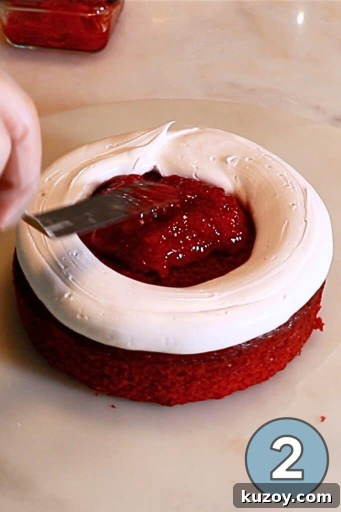 Vintage Pink Cake Ideas for Elegant Party Desserts 10 spreading stawberry jam on a first layer of red velvet cake