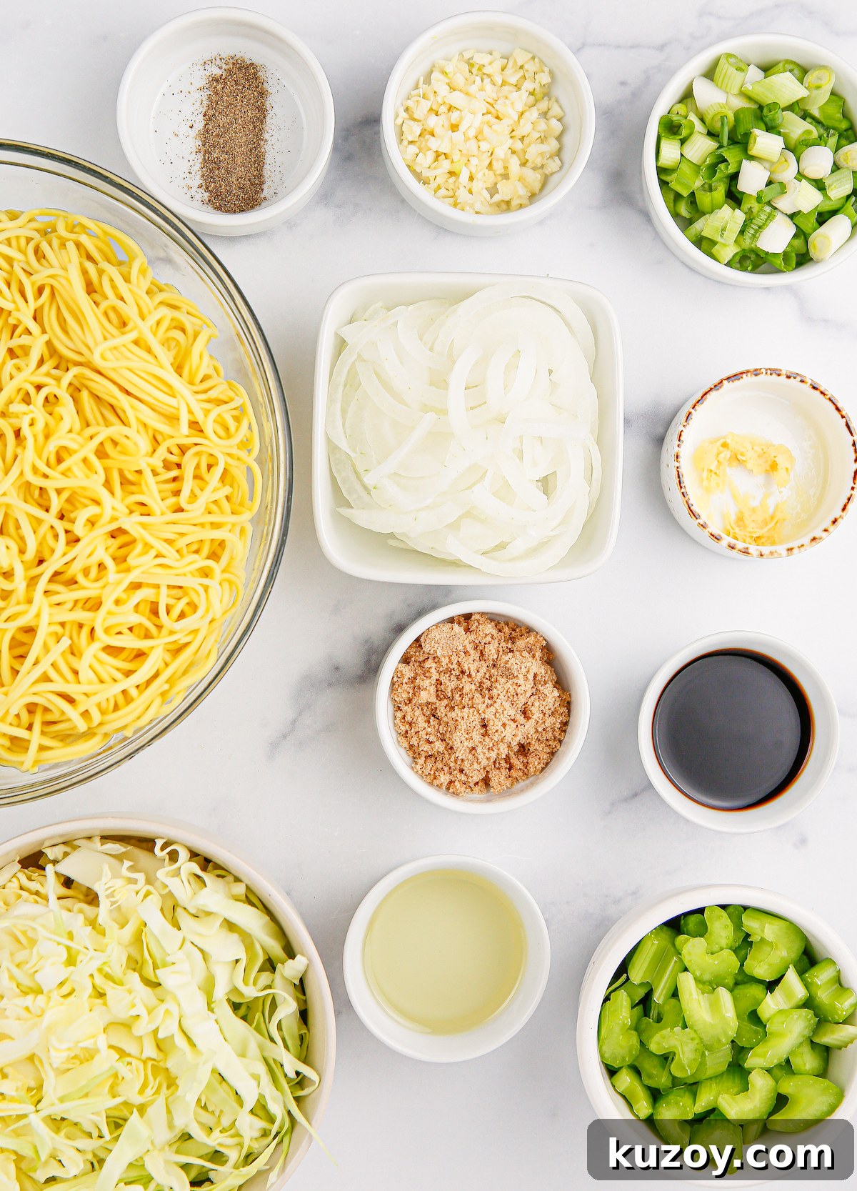 Panda Express Chow Mein Recipe: Copycat Version for Home Cooking 4 All the ingredients to make Panda Express chow mein in prep bowls on a white marble background.