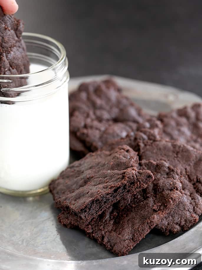 Gluten free brownie crisps being dipped in milk