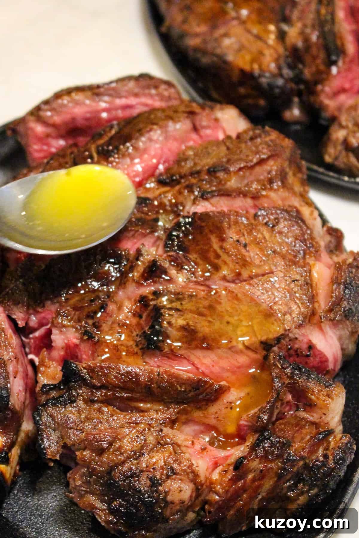 Garlic butter being drizzled over Peter Luger Style Steak.