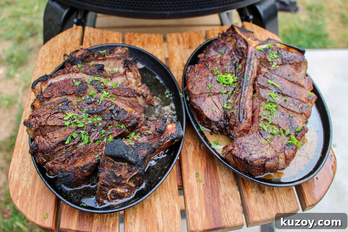 two peter luger style steaks on platters set on a cutting board overhead