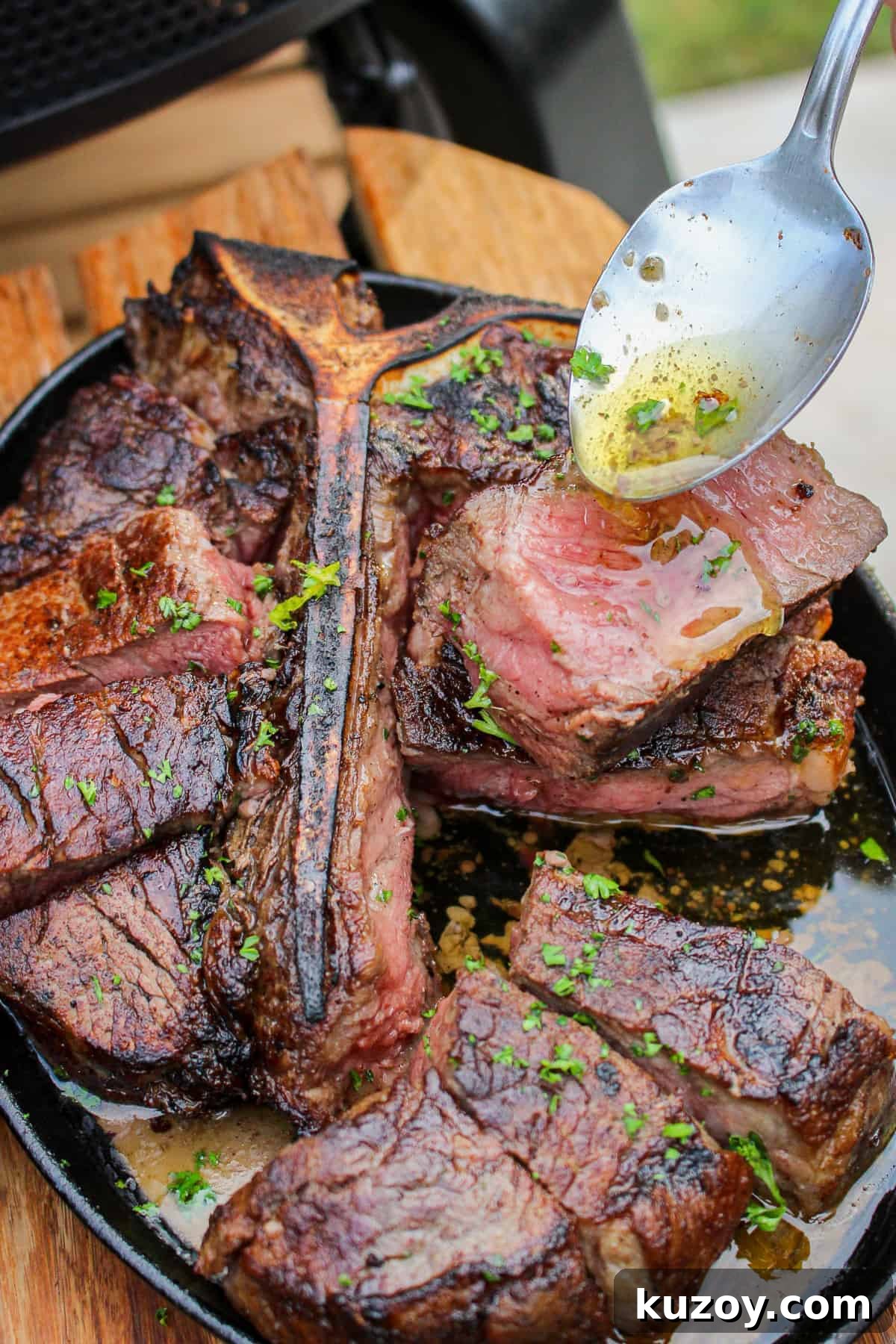 closeup of Peter Luger Style Steak being drizzled with garlic butter