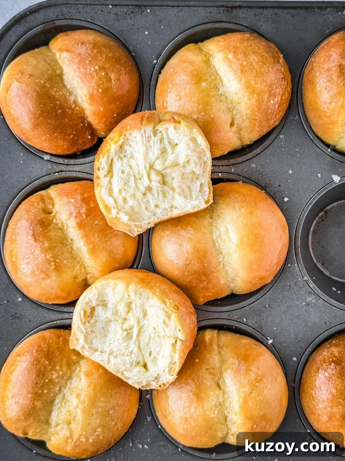 Soft, Buttery Double-Crust Dinner Rolls 8 Double cheeked buns in a muffin tin showing the cross section of one of the buns.