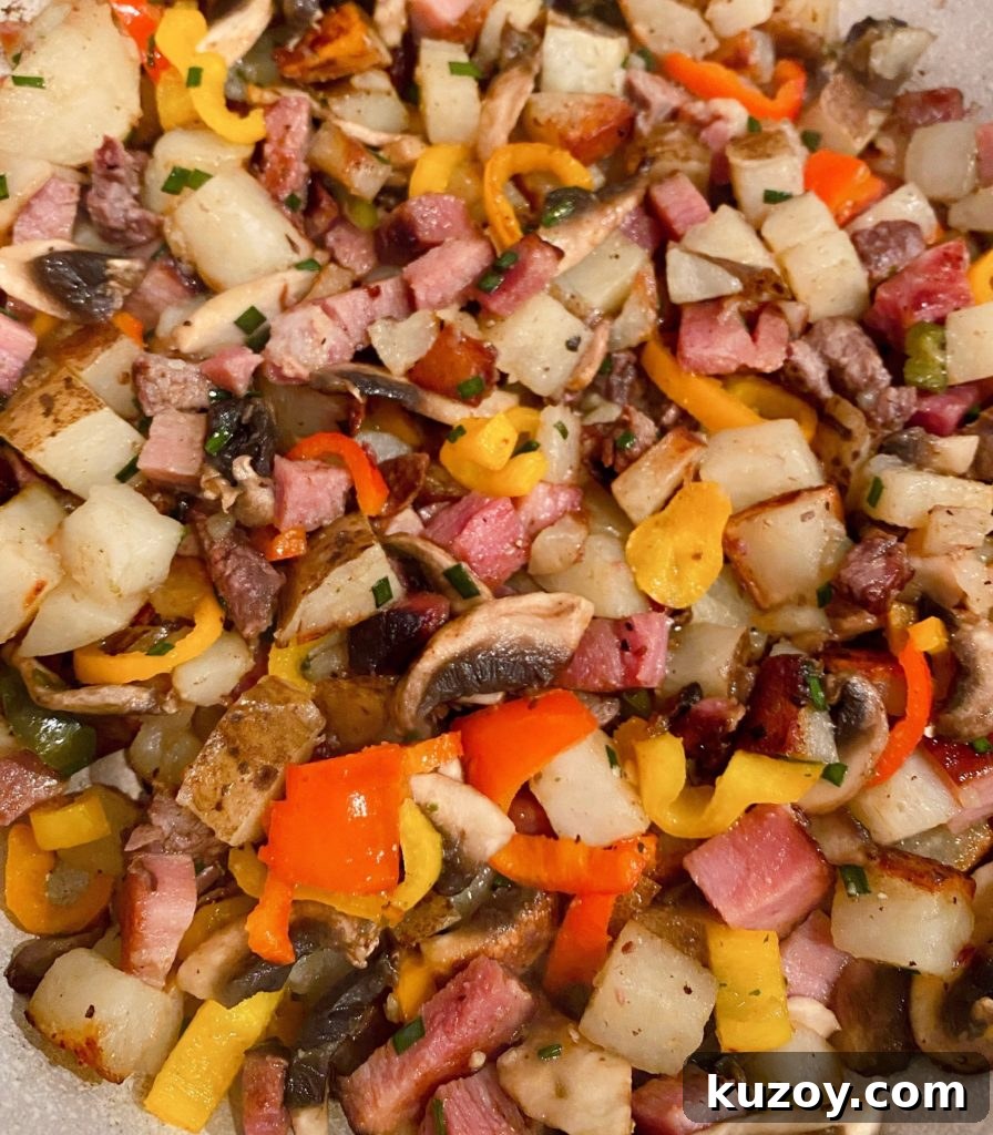 Country Skillet Breakfast Scramble with Sausage & Potatoes 4 Cooked Potatoes, meat, and veggies in skillet.