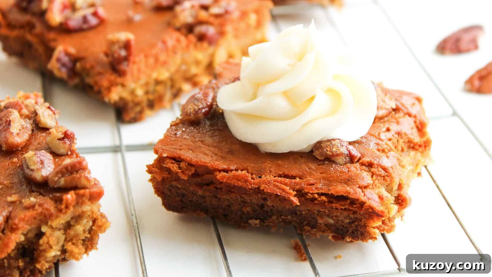33 Must-Bring Thanksgiving Potluck Recipes for Every Year 11 A square piece of pumpkin dessert bar topped with a swirl of white frosting and pecans sits on a cooling rack.