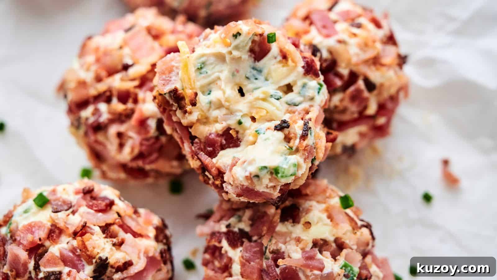 33 Must-Bring Thanksgiving Potluck Recipes for Every Year 16 Close-up of several Bacon Jalapeno Popper Cheese Balls wrapped in bacon, stuffed with cheese, and seasoned with herbs and spices, placed on crumpled parchment paper.