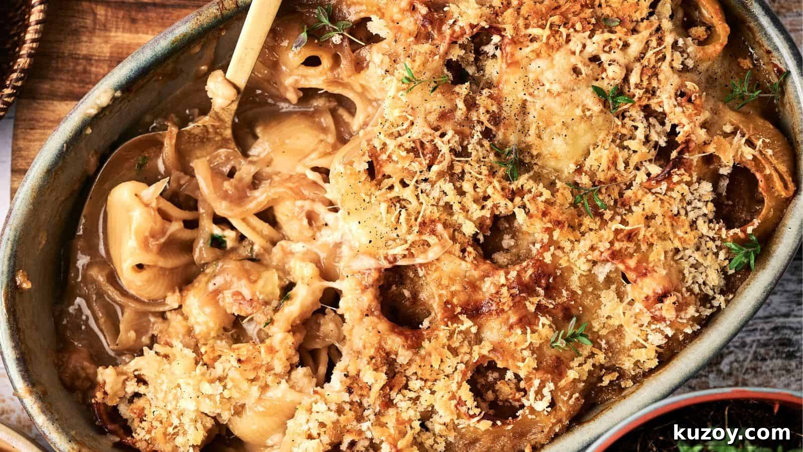 33 Must-Bring Thanksgiving Potluck Recipes for Every Year 7 A baked casserole dish filled with creamy macaroni and cheese, topped with a golden-brown breadcrumb crust and garnished with fresh herbs.