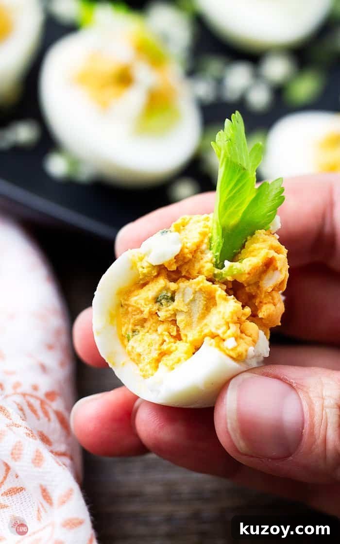 Buffalo Chicken Deviled Eggs Recipe for Game Day or Parties 7 close up of a bite out of a buffalo chicken egg