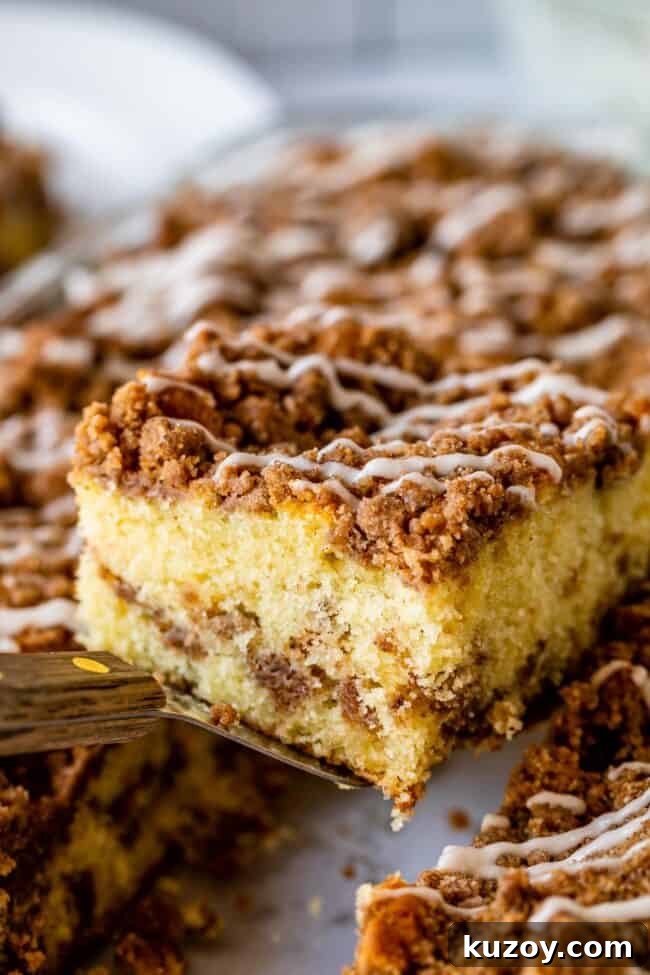 Slice of streusel coffee cake on spatula Streusel topped coffee cake slice being lifted on a spatula from pan.